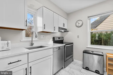 a kitchen with stainless steel appliances granite countertop a sink and a stove next to a window
