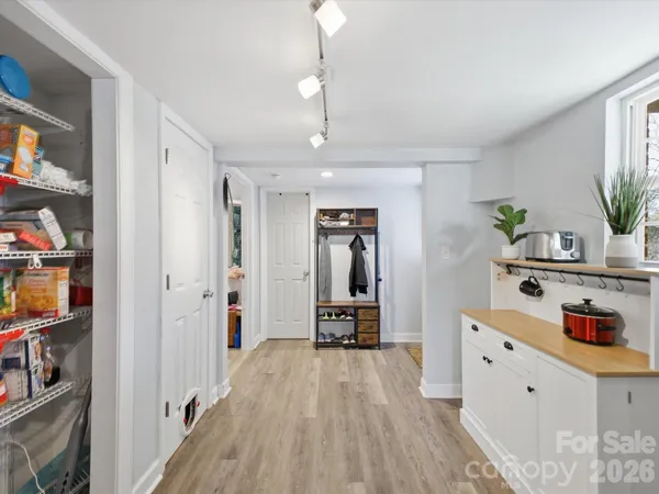 a hallway with cabinets and wooden floor