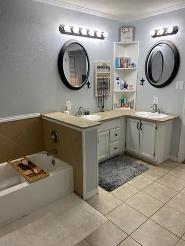 a bathroom with a granite countertop toilet sink and mirror