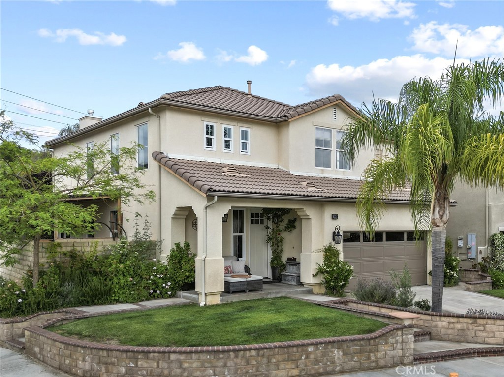 a front view of a house with a yard and potted plants