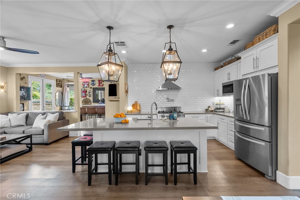 19969 Via Joyce Drive Saugus, CA 91350 - Photo 19 of 66 a kitchen with stainless steel appliances a dining table chairs stove refrigerator and microwave