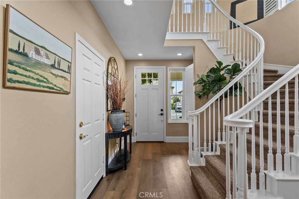 19969 Via Joyce Drive Saugus, CA 91350 - Photo 31 of 66 a view of staircase with lots of frames on wall and wooden floor