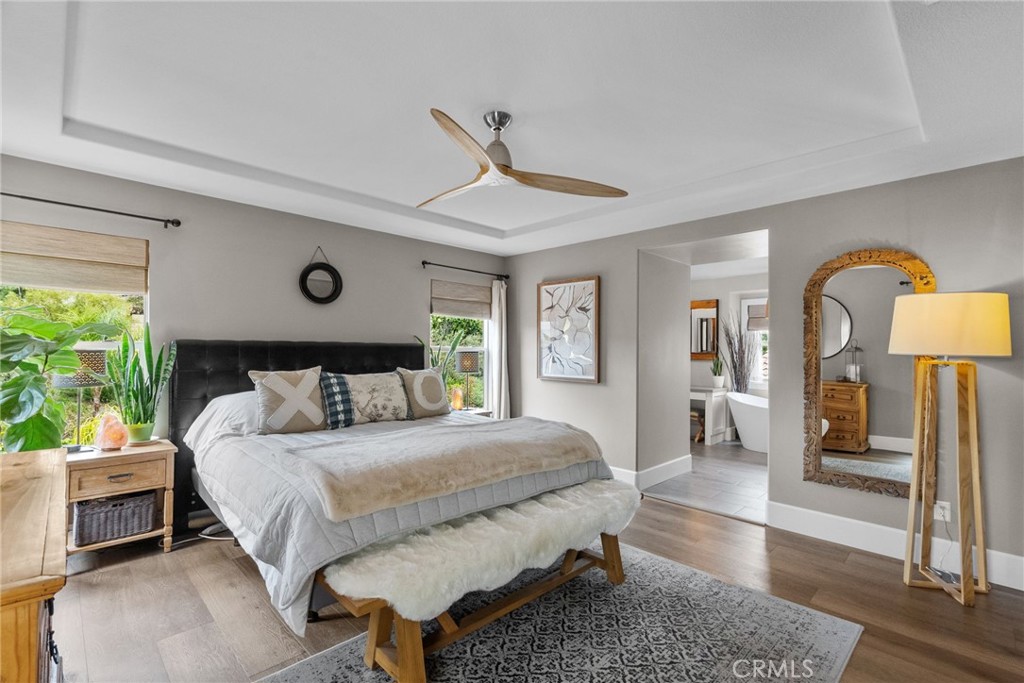 19969 Via Joyce Drive Saugus, CA 91350 - Photo 42 of 66 a bedroom with a bed a mirror and lamp next to a window