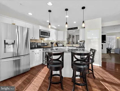a kitchen with stainless steel appliances granite countertop a stove a sink and a white cabinets