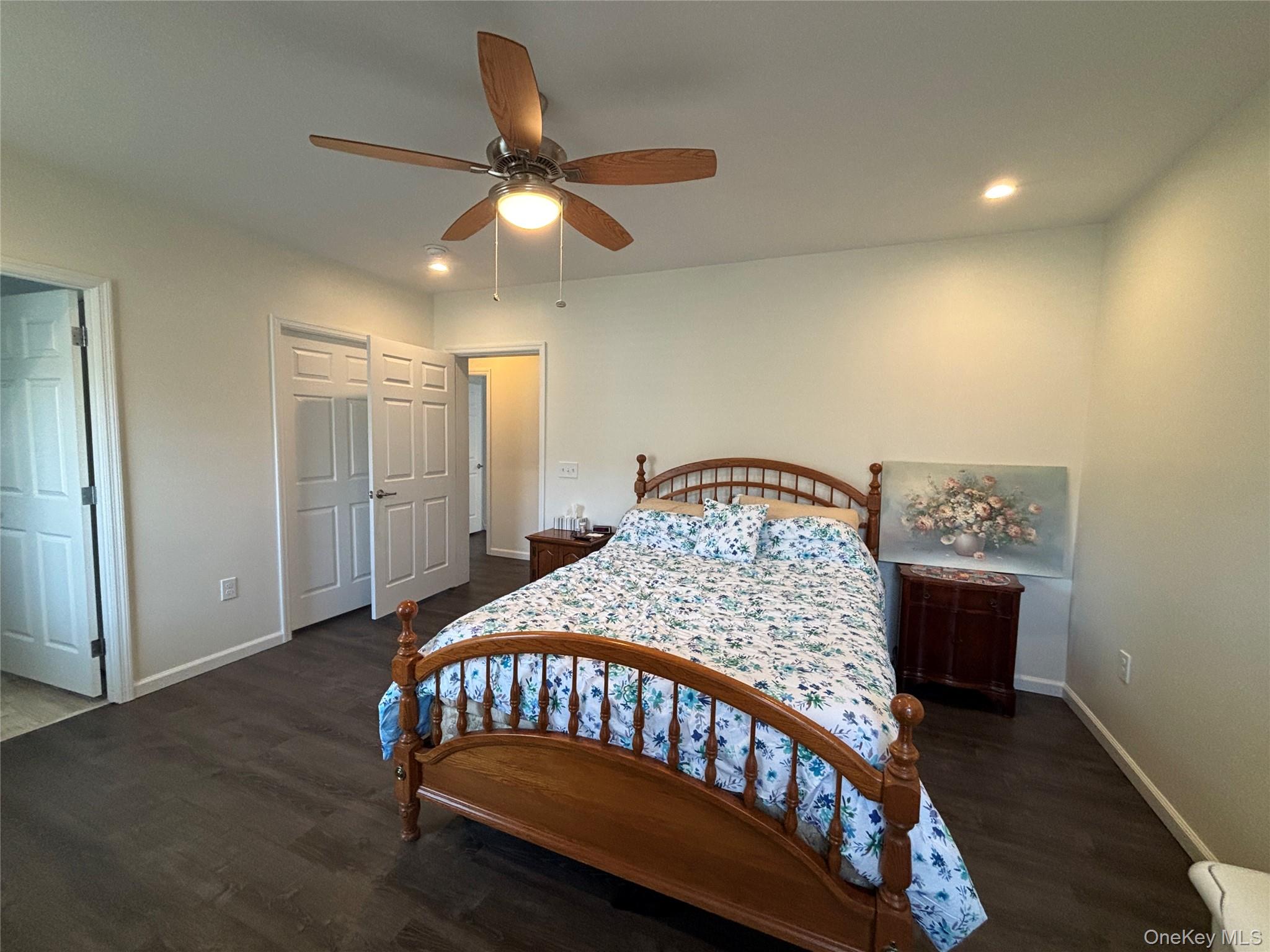 1661 Old Country Road, Unit 563 Riverhead, NY 11901 - Photo 30 of 43 a bedroom with a bed and a chandelier