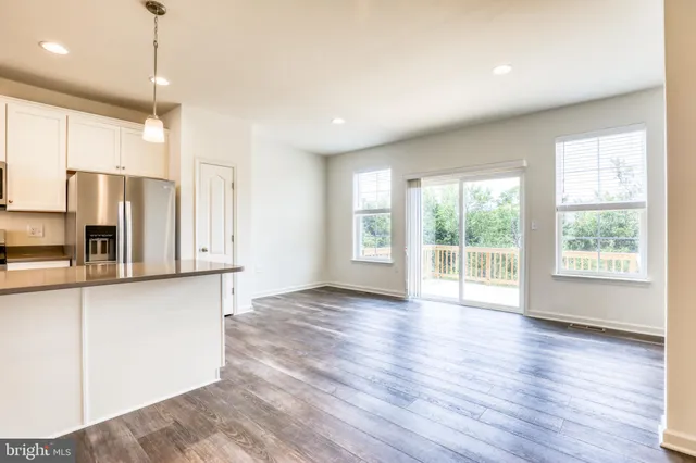 a view of kitchen with refrigerator microwave and wooden floor