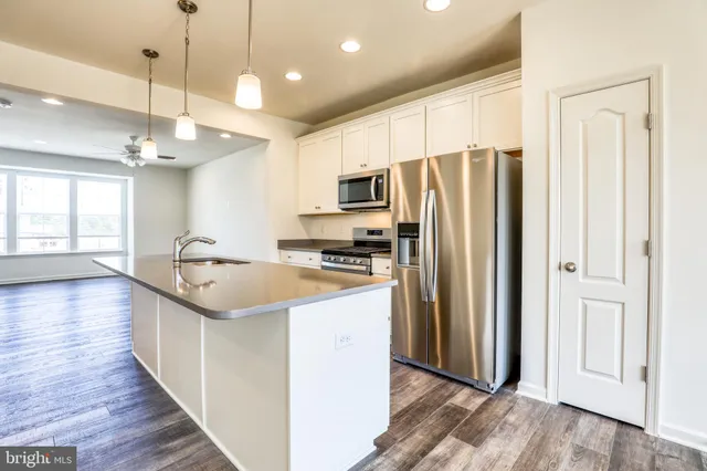 a view of a kitchen with wooden floor and a window