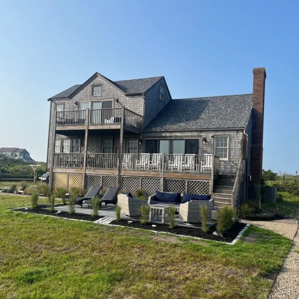 22 Sheep Pond Road Nantucket, MA 02554 - Photo 3 of 27 a front view of a house with a yard table and chairs