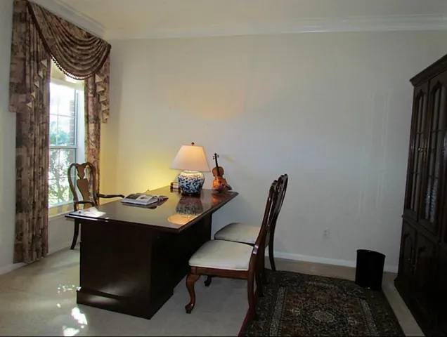 a view of a workspace with furniture and a window