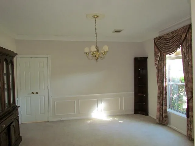 a view of a livingroom with a chandelier fan and windows