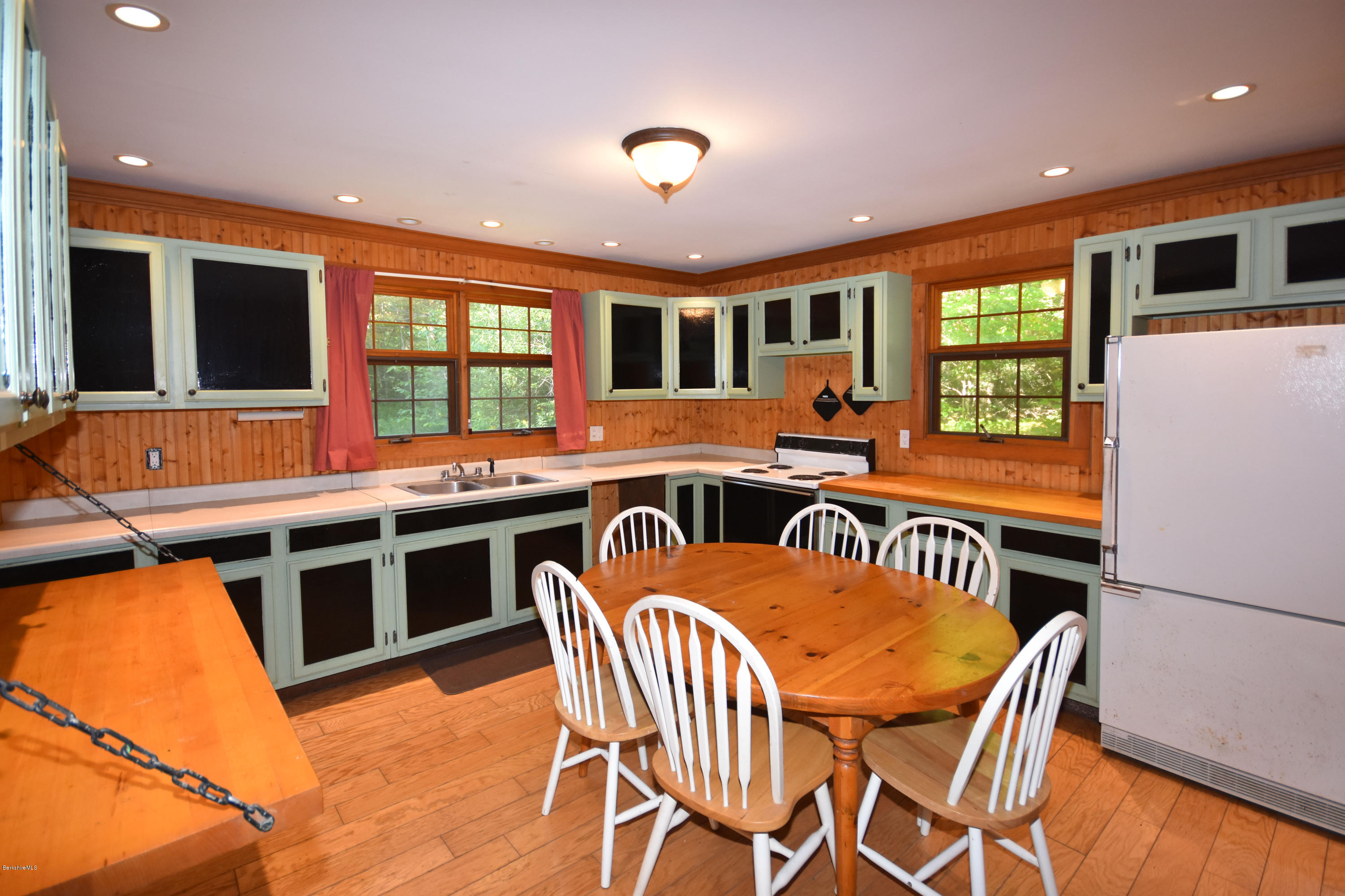 211 Woodmere Road Becket, MA 01223 - Photo 14 of 56 a kitchen with stainless steel appliances granite countertop a stove a refrigerator a dining table and chairs with wooden floor