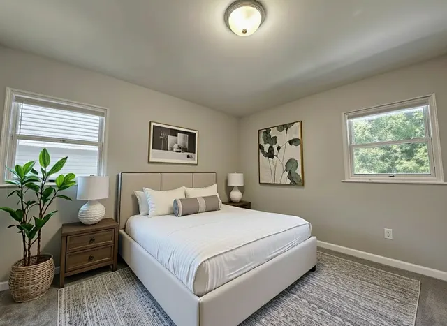 a bedroom with a large bed and a potted plant