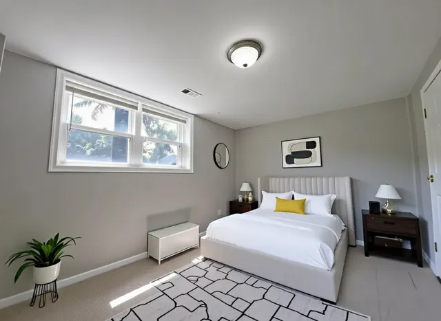 a bedroom with a large bed and a potted plant