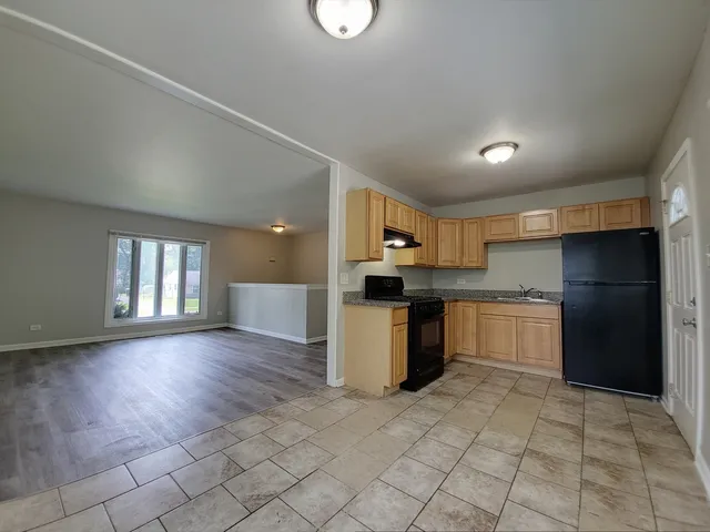 a kitchen with a refrigerator and a stove top oven