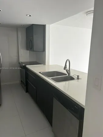 a kitchen with a sink and a stove top oven