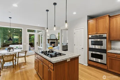 a kitchen with stainless steel appliances kitchen island granite countertop a stove a refrigerator and a wooden cabinets