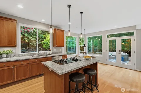 a kitchen with a stove a sink a counter top space and living room view