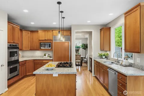 a kitchen with stainless steel appliances granite countertop sink stove and refrigerator