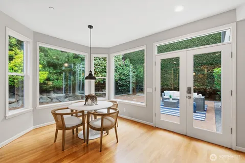 a dining room with furniture large windows and wooden floor