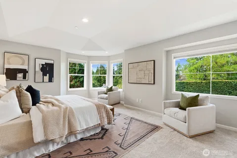 a spacious bedroom with a bed and glass window