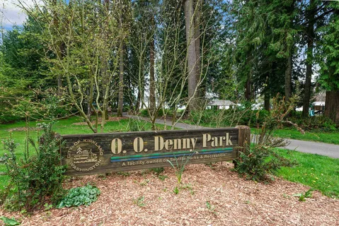 a sign that is sitting in front of a tree