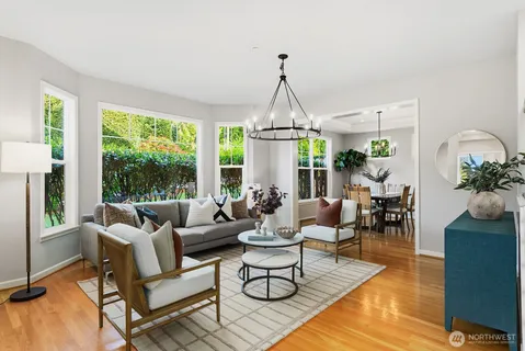 a living room with furniture chandelier and a wooden floor