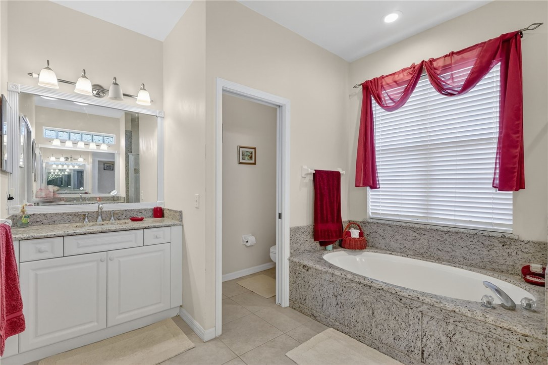 3075 73rd Place Vero Beach, FL 32967 - Photo 11 of 30 a bathroom with a tub sink and mirror