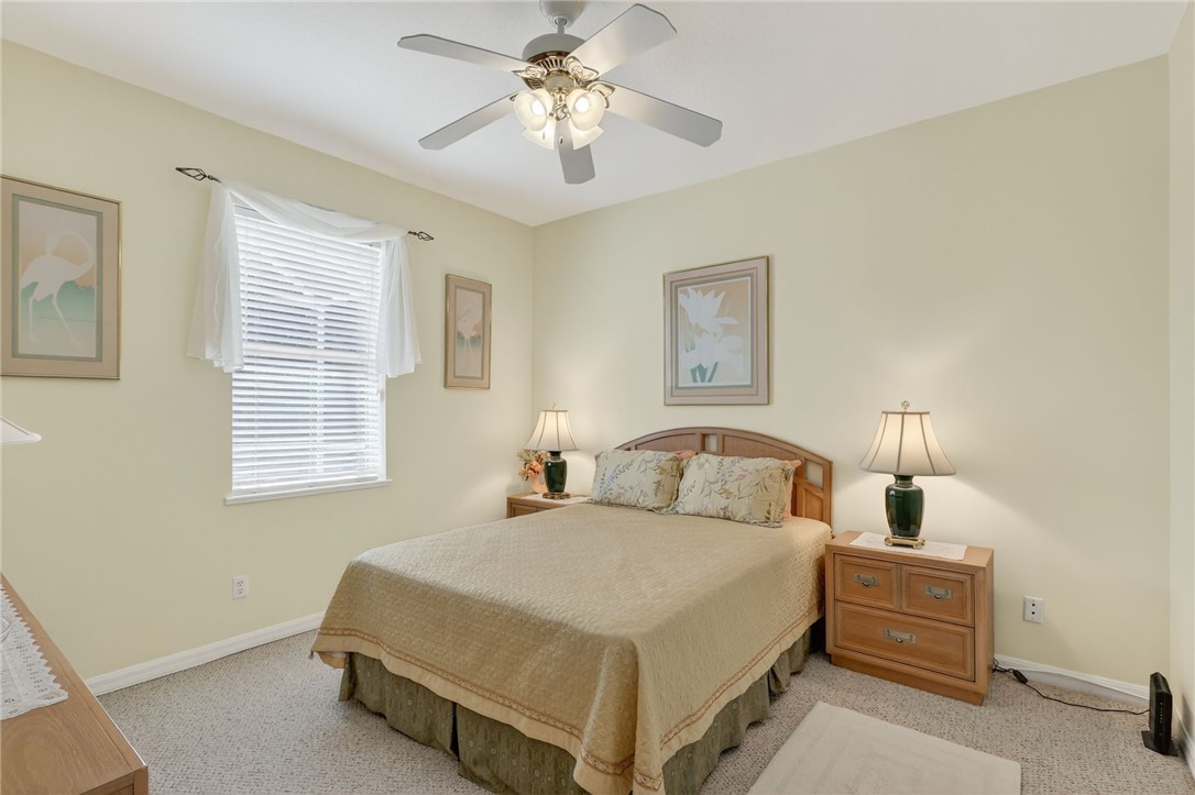 3075 73rd Place Vero Beach, FL 32967 - Photo 14 of 30 a bedroom with a bed and a chandelier