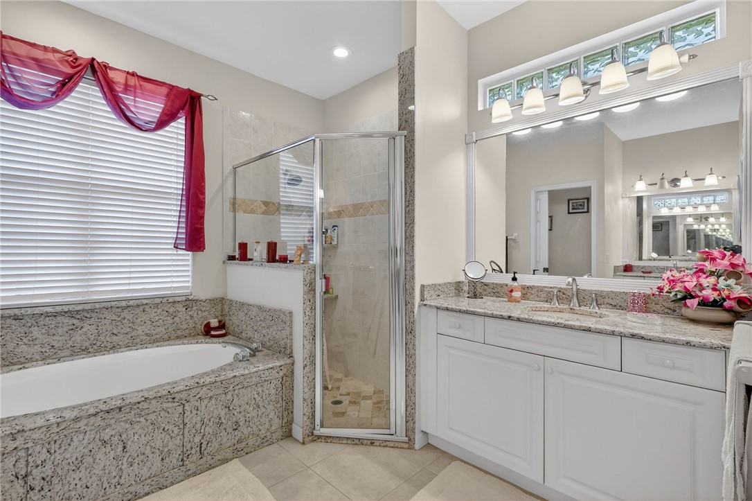 3075 73rd Place Vero Beach, FL 32967 - Photo 10 of 30 a bathroom with a granite countertop sink mirror and a bathtub