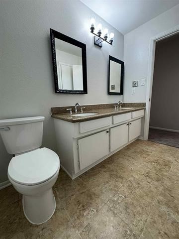 6349 Ivanhoe Lane Beaumont, TX 77706 - Photo 9 of 10 a bathroom with a toilet sink and mirror