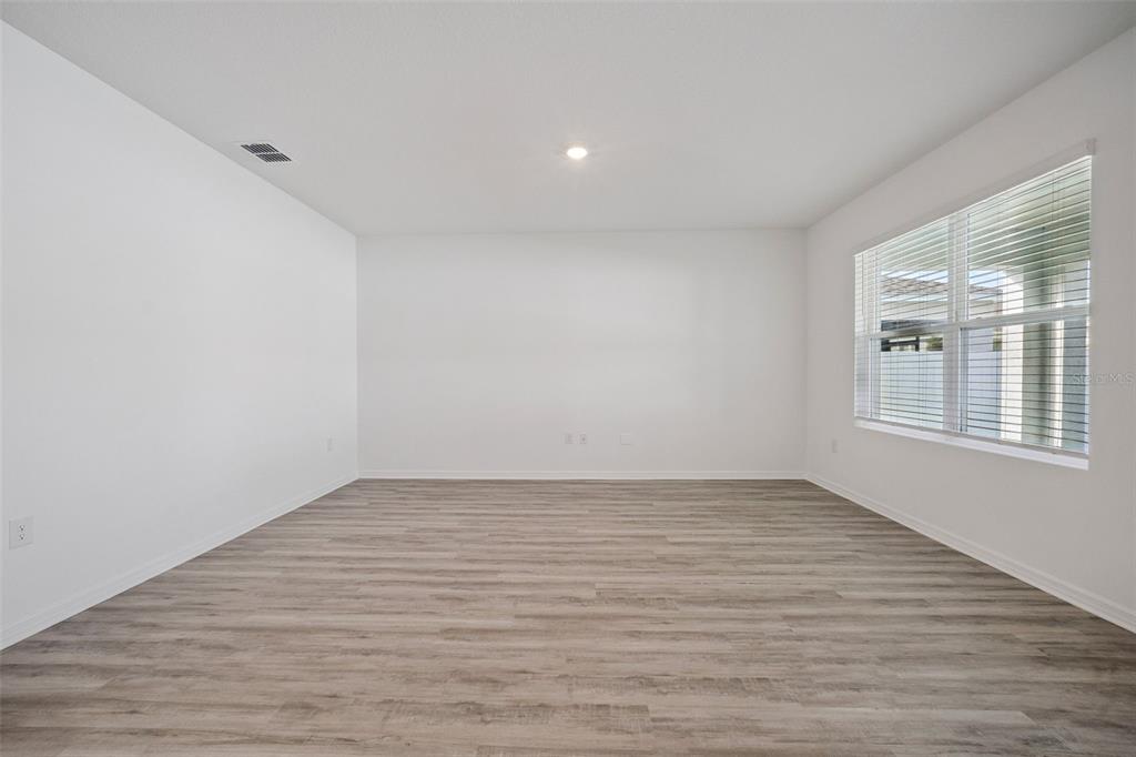 3515 Nettle Loop Tavares, FL 32778 - Photo 12 of 58 a view of an empty room with wooden floor and a window