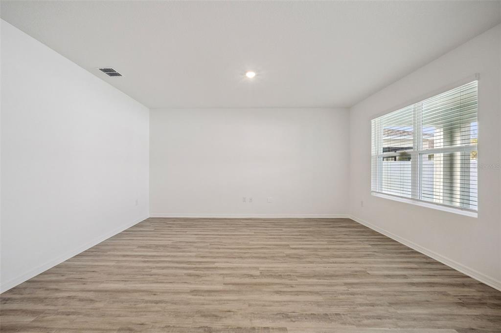 3515 Nettle Loop Tavares, FL 32778 - Photo 13 of 58 a view of an empty room with wooden floor and a window