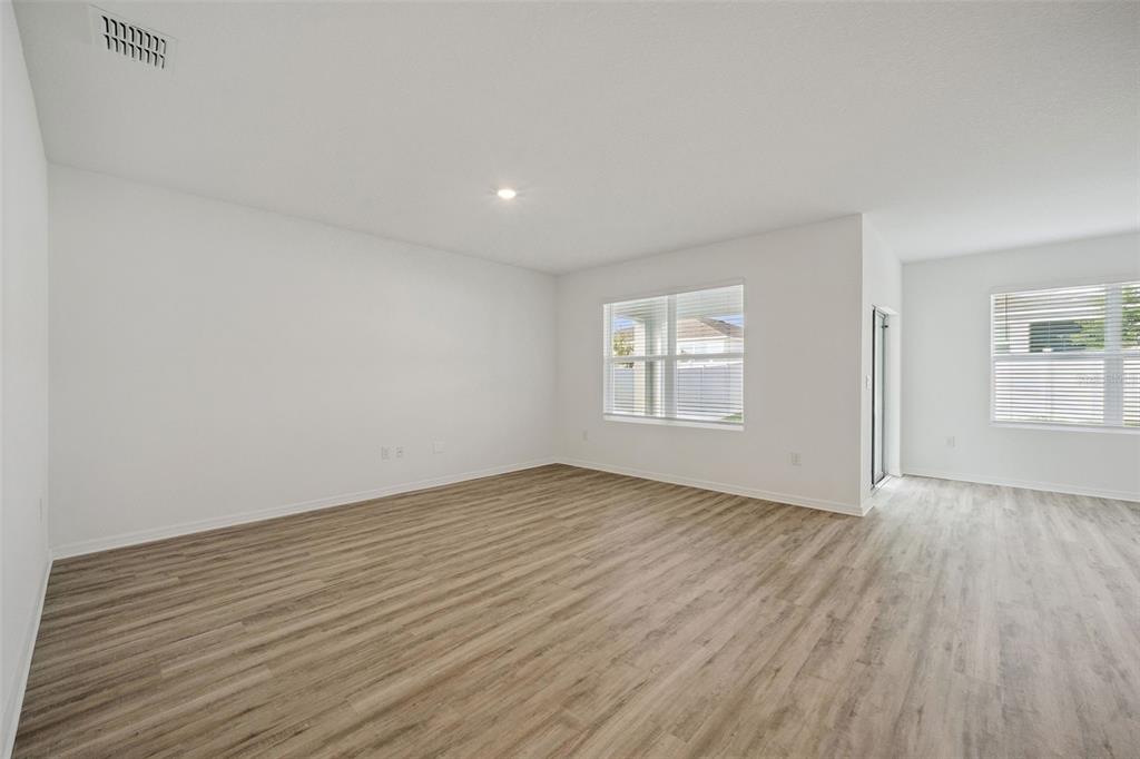 3515 Nettle Loop Tavares, FL 32778 - Photo 4 of 58 an empty room with wooden floor and windows