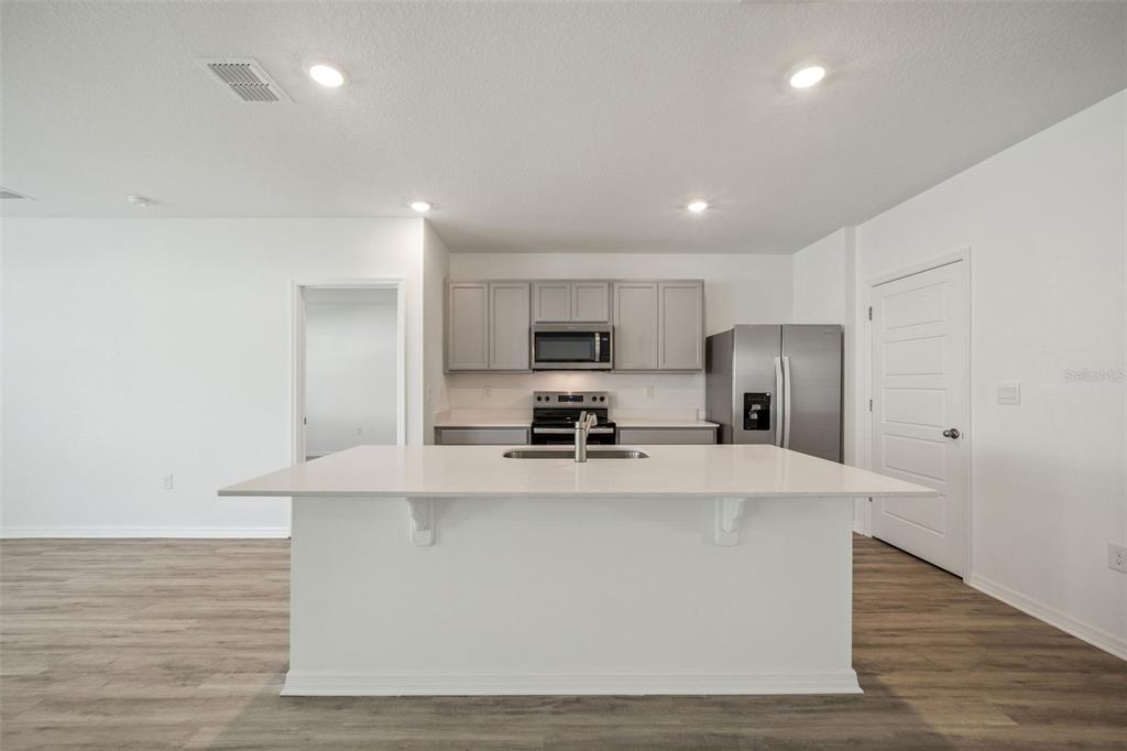 3515 Nettle Loop Tavares, FL 32778 - Photo 8 of 58 a kitchen with stainless steel appliances a refrigerator sink and stove
