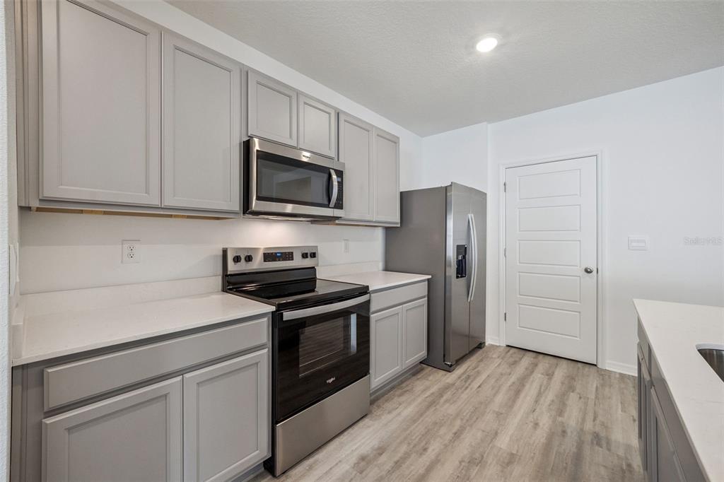 3515 Nettle Loop Tavares, FL 32778 - Photo 10 of 58 a kitchen with a stove microwave and refrigerator