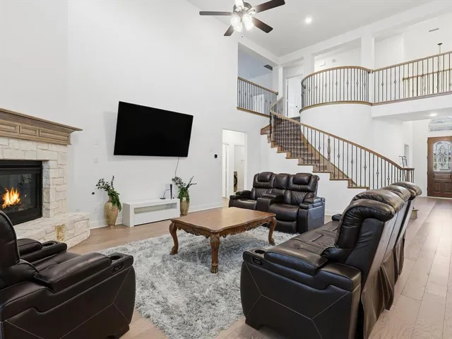 a living room with furniture a flat screen tv and a fireplace
