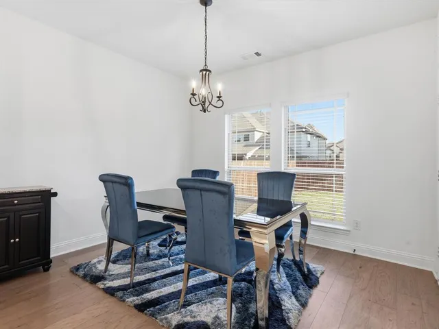 a view of a dining room with furniture a chandelier and wooden floor