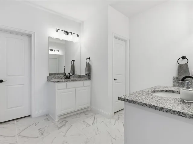a bathroom with a granite countertop sink and a mirror