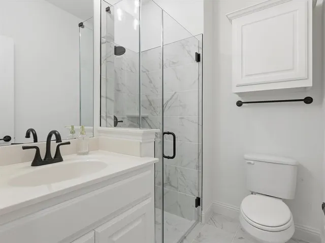 a bathroom with a toilet a sink and shower