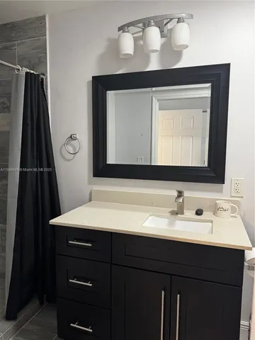 a bathroom with a sink vanity and a mirror
