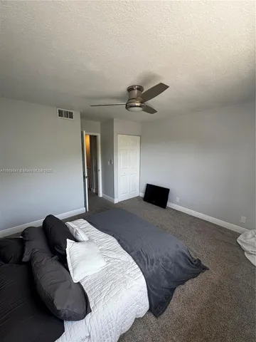 a bedroom with a bed and a ceiling fan