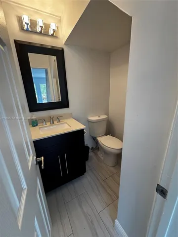 a bathroom with a toilet a sink and a mirror