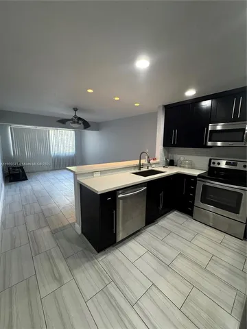 a kitchen with stainless steel appliances kitchen island granite countertop a sink and cabinets
