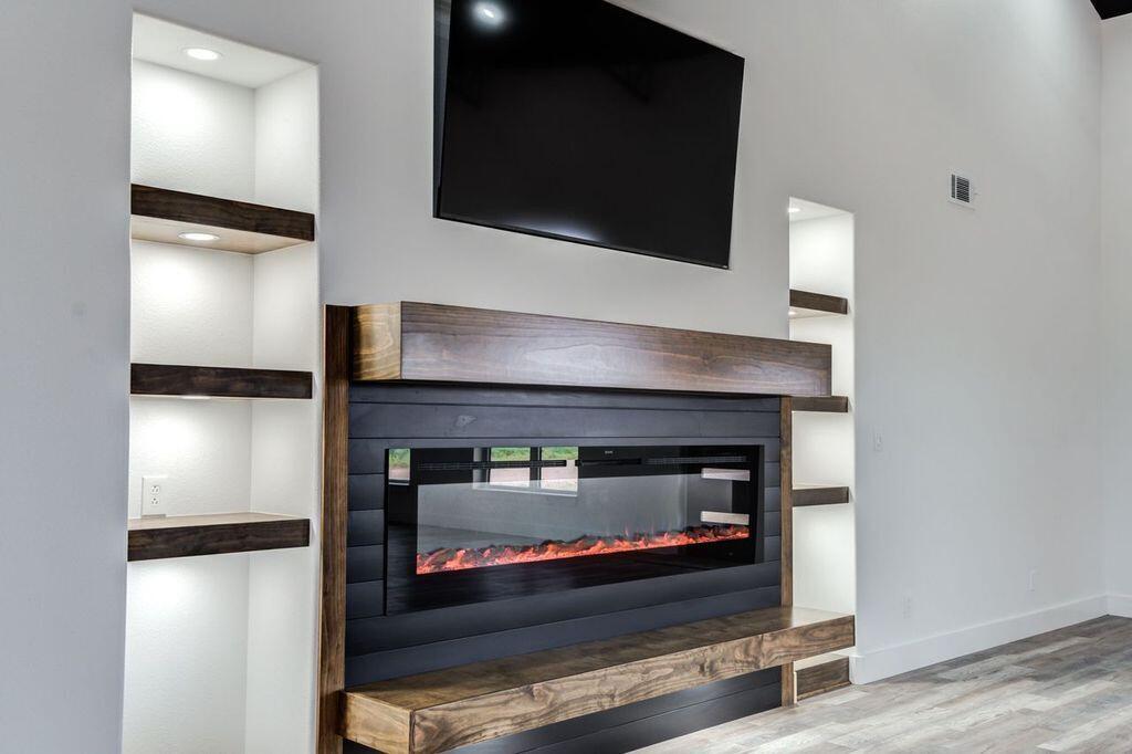6601 North C R 1500 Shallowater, TX 79363 - Photo 14 of 39 a fireplace with a flat screen tv