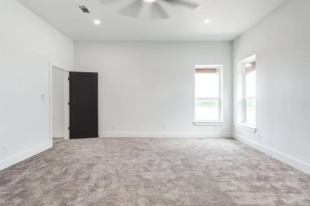 an empty room with windows and closet