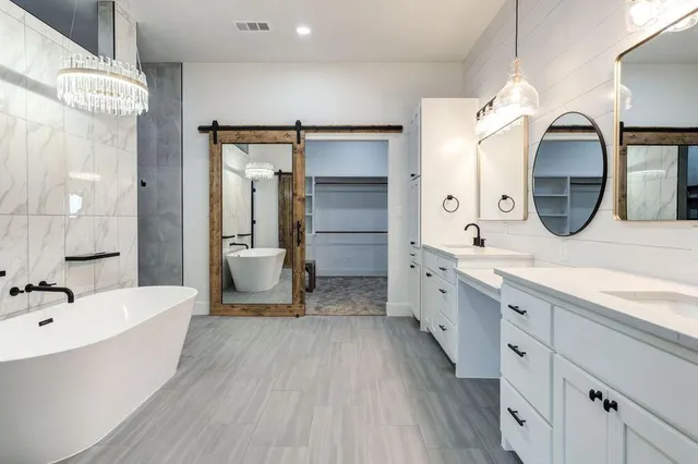 a large bathroom with a double vanity sink mirror and bathtub