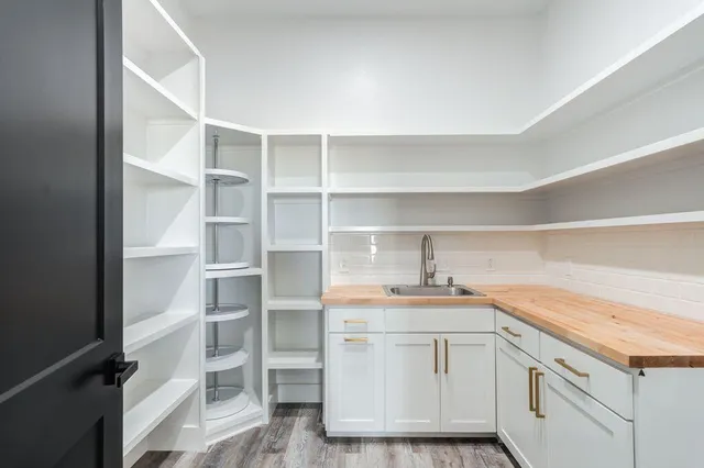 a kitchen with a sink cabinets and a wooden floor