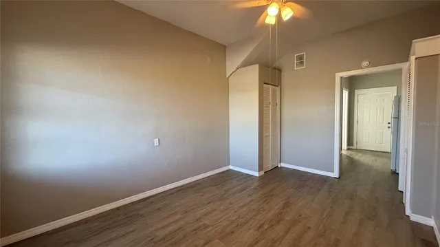 a view of an empty room with wooden floor