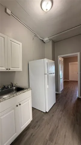 a kitchen with a sink a refrigerator and cabinets