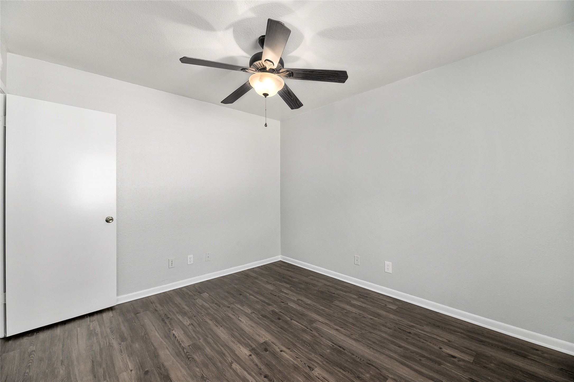 2408 Longview Street, Unit 113 Austin, TX 78705 - Photo 15 of 23 Empty room featuring dark wood-style floors and a ceiling fan